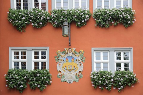 City coat of arms with floral decoration, orange house facade with window, town hall, Idstein,