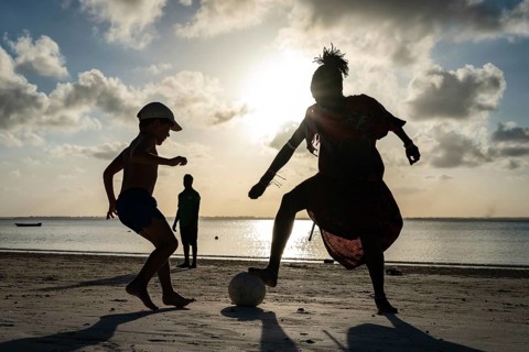 MICHAMVI KAE, ZANZIBAR - OCTOBER 14, 2025: Silhouette of a Maasai man and a young boy playing