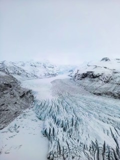 Aerial view of Iceland's winter landscape showcasing vast glaciers and rugged terrain. The frozen