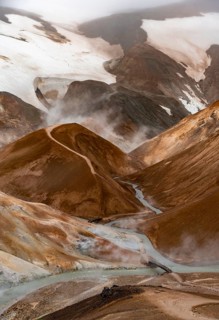 Bridge and steaming streams between colourful rhyolite mountains and snowfields, Hveradalir