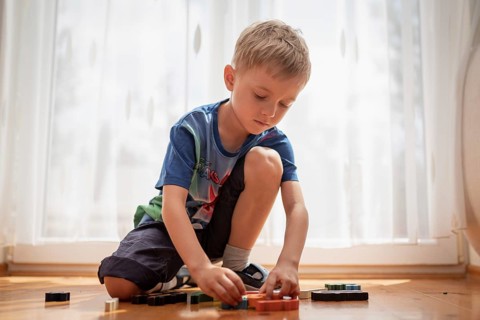 5-6 old boy play with blocks puzzle in Tymowa, Poland