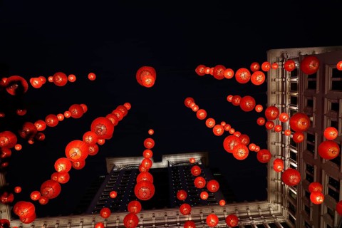 From below a festive red lanterns adorn a classical building in Hong Kong, brilliantly lit against