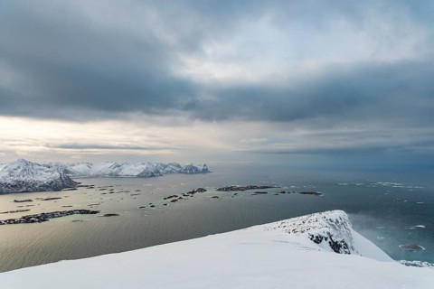 View of the snow-capped mountains of Senja Island and the open sea, Troms, Norway