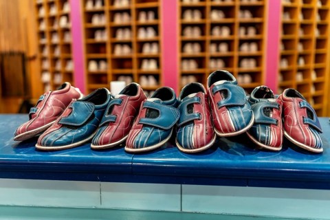 Red and blue bowling shoes resting on a counter, inviting bowlers to rent and enjoy an exciting