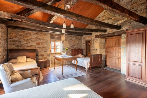 Charming, rustic bedroom interior featuring stone walls, wooden beams, and vintage furniture,