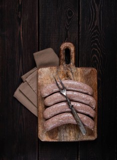 Raw sausages in English with bacon, for grilling, on a cutting board, top view, no people