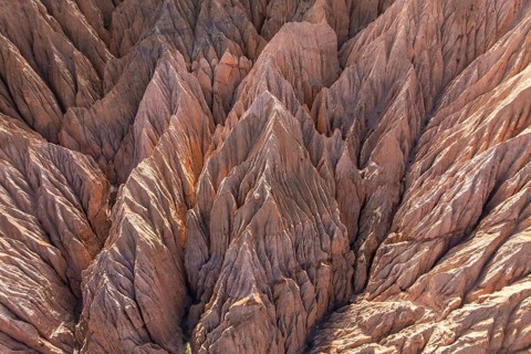 Aerial view of dramatic gully erosion carving deep channels into rugged terrain, showcasing the