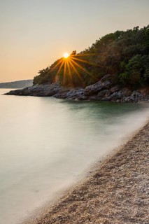 Crystal clear and turquoise water on the beach of Ustrine Bay on a sunny day at sunset on the