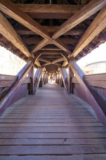 Elongated wooden bridge with visible beams in tunnel view, Schwäbisch Hall, Germany