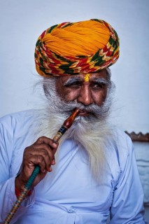 JODHPUR, INDIA, NOVEMBER 26, 2012: Old Indian man smokes hookah (waterpipe) in Mehrangarh fort. The