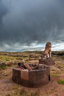 Round ruin structures under a dark, stormy sky, The Chullpas of Sillustani near Puno in Peru