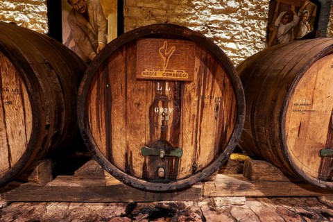 Wooden barrels in a rustic setting with stone walls, Achaia Clauss winery, Patras, Peloponnese,