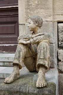 Sculpture in front of the old school building, art in public space, stone figure, sculpture by the