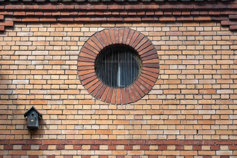 A round window, also called oculus, ox eye in a brick wall, decorated, historic old town of