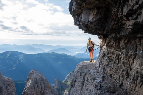 Climbers on a rock band, Bocchette Centrale band trail, via ferrata in the Brenta Mountains,