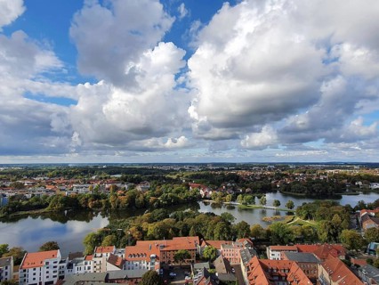 View from above of Szczecin city view with red roofs and a lake in the foreground, surrounded by