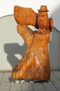 Owl figure with hat on the adventure trail, wooden sculpture, handicraft, headdress, wings, detail,