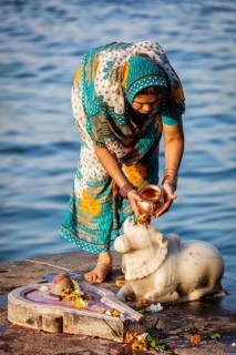 MAHESHWAR, INDIA, APRIL 26: Indian woman performs morning pooja on sacred river Narmada ghats on