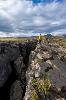 Tourist at a crevice, Grjótagjá, Myvatn, Iceland