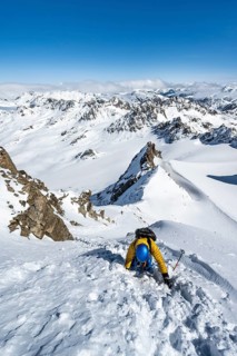 Mountaineer with ice axe and crampons, ascent through steep snowfield to Piz Kesch or Piz d'Es-cha