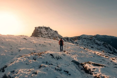 A lone hiker traverses the snow-covered trails of Siete Picos in Guadarrama Mountains, Madrid. The