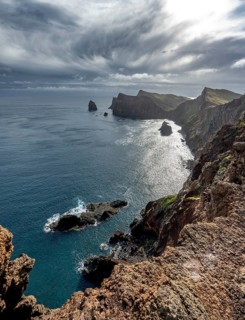 Red cliffs and rocks in the sea, coastal landscape with dramatic sky, Ponta de São Lourenço,