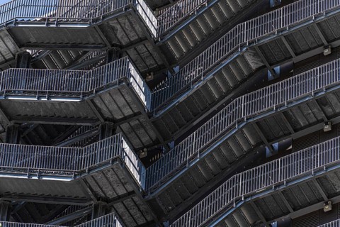 A striking image of urban metal stairs exhibiting a geometric design. The intricate architecture