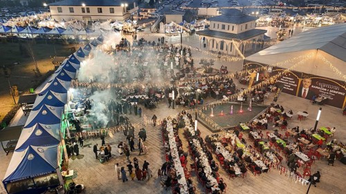 Aerial view captures hundreds of Muslims gathered at long tables for a communal Iftar meal in a