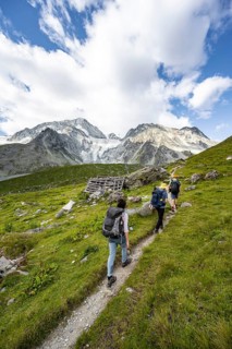Mountaineer on a hiking trail, mountain landscape near Arolla, behind glacier Glacier de Tsijore