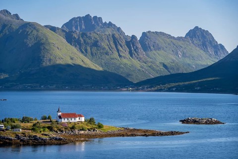 Small church Sildpollnes Kirke at the fjord Austnesfjorden, idyllic Norwegian fjord landscape,