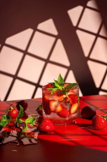 A refreshing strawberry mojito features fresh strawberries, mint leaves, and a hint of lime, served