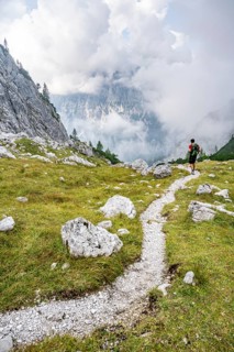 Mountaineer on a hiking trail, cloudy mountains, descent over the Ofental, mountain tour on the