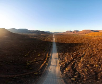 Aerial view, infinite space, straight road leads through dry desert landscape, hills in Damaraland,