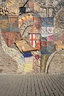 Relief and text about the city's history, scroll, city coat of arms, city chronicle, wall mosaic,