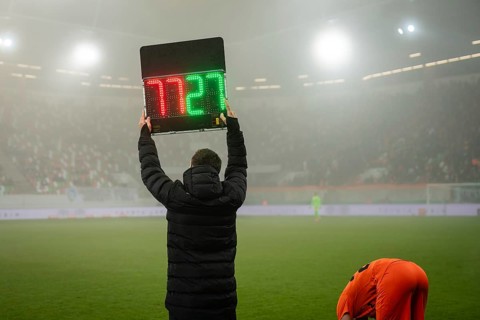 Technical referee shows players substitution during football match in Lubin, Poland