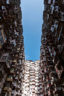 From below a dramatic view of dense residential buildings in Hong Kong. High-rise structures