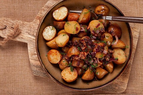 Delicious roasted potatoes are mixed with caramelized onions and fresh herbs, creating a