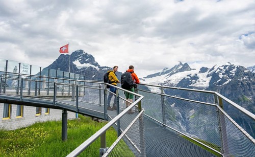 Tourists on the First Cliff Walk, metal trail on a rocky outcrop, Grindelwald First, in front of