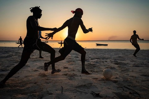 MICHAMVI KAE, ZANZIBAR - OCTOBER 19, 2025: Silhouetted young men play a competitive game of soccer