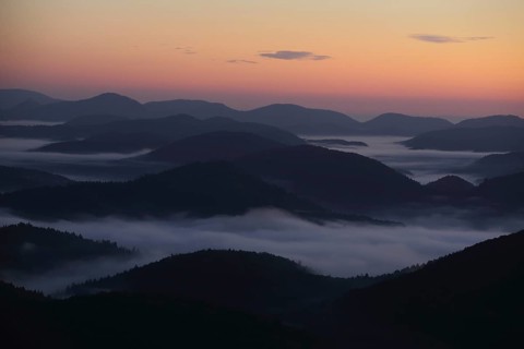 Landscape with mountains and clouds of fog in front of sunrise, nature photography, blue hour,