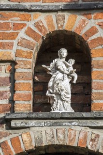 Statue of Virgin Mary with Baby Jesus in alcove above entrance door at the 17th century Beguinage