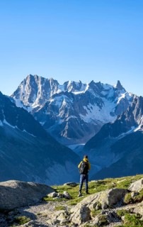 Young man in front of impressive mountain landscape in morning light, picturesque mountain