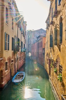 View on a waterway with boats lying in the water in Venice on a sunny day in winter, Italy