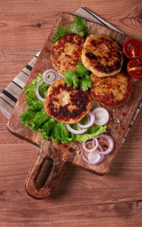 Fried chicken cutlets, minced chicken, with vegetables, on a cutting board, with vegetable salad,