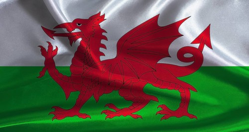 Wales flag with cloth textured background. National flag of Wales with realistic texture