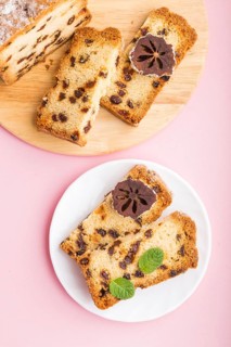 Homemade cake with raisins and dried persimmon on a pink pastel background. Top view, flat lay,