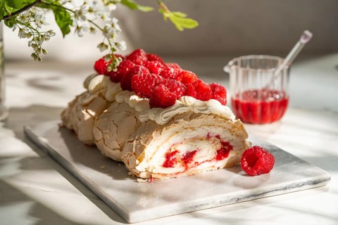 Delightful raspberry meringue roulade featuring creamy layers rolled into a perfect dessert, topped