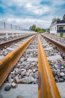 Close-up view of rails with stone bedding running into the distance under a cloudy sky, track