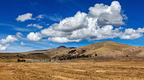 Wide, hilly landscape under a dramatic sky with powerful clouds, The villages and countryside near