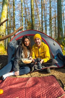 Photographers enjoying a meal together in front of their tent, savoring moments of relaxation